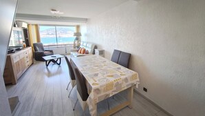 Un salon moderne avec une table à manger, un canapé et une vue sur la mer.