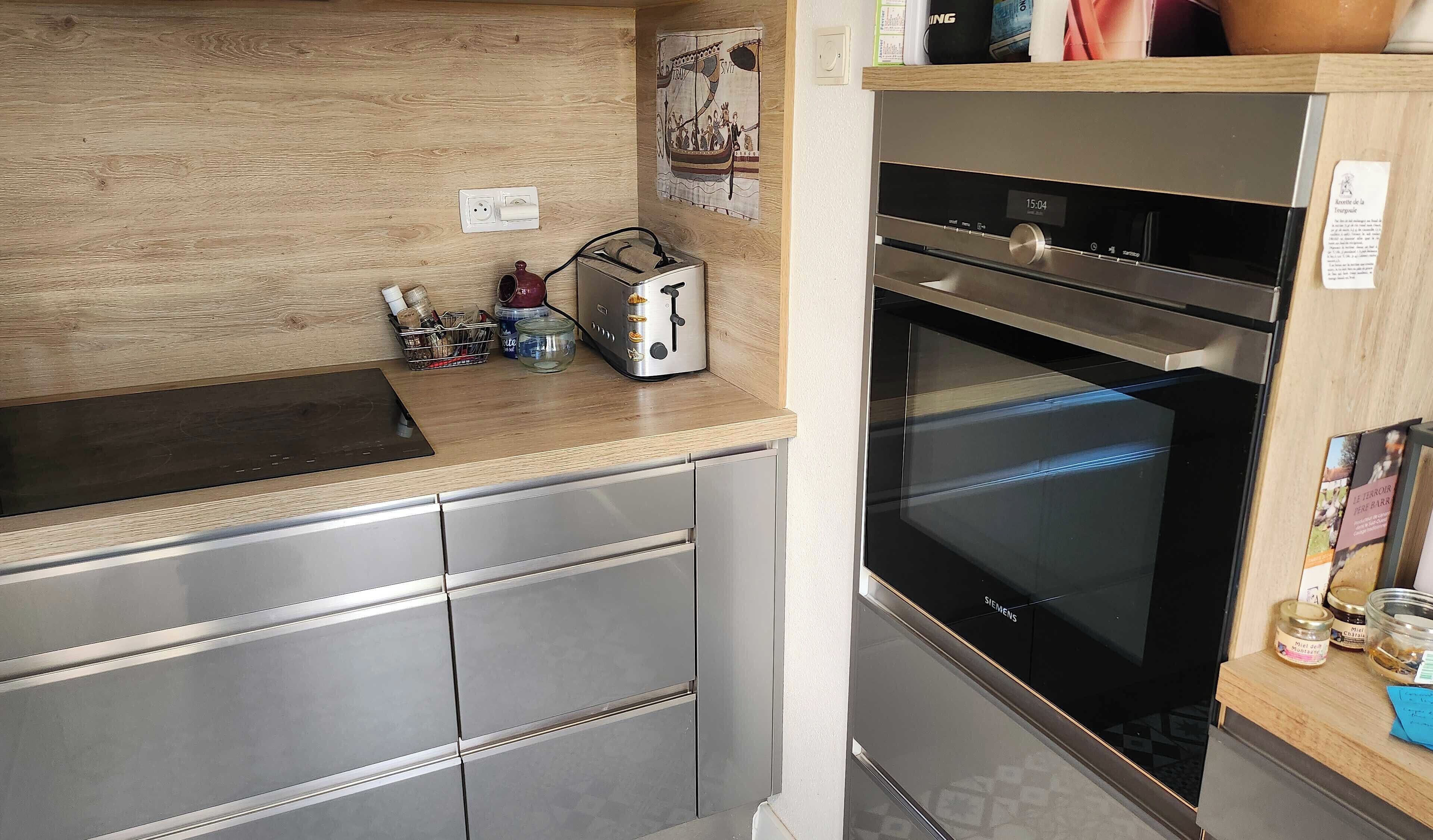 Una cucina moderna con forno integrato, un tostapane e un piano di lavoro in legno.
