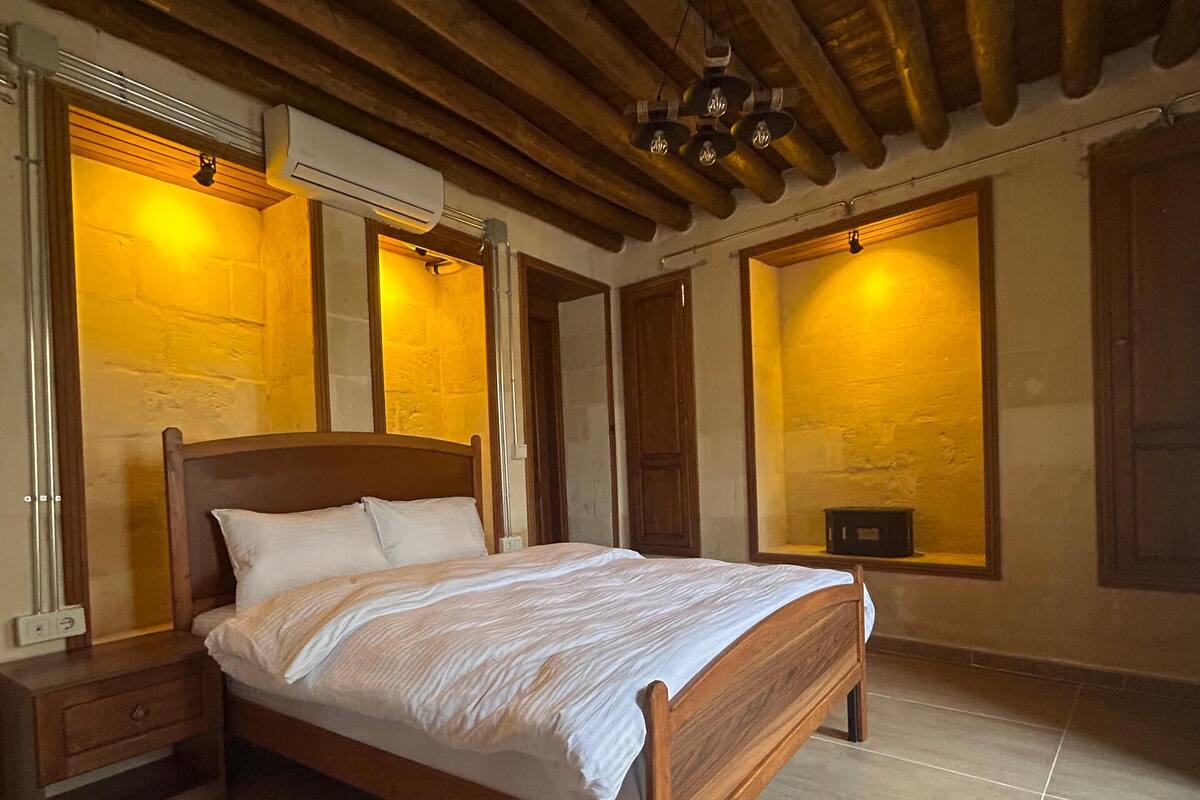 Une chambre à coucher avec un lit en bois, des tables de chevet et un plancher carrelé.