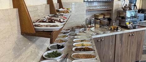 Ein reichhaltiges Buffet mit verschiedenen Speisen und einer Kaffeemaschine.