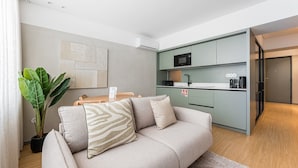 A modern living room with a sofa, a coffee table, and a potted plant. - GuestReady - Exquisite stay in Matosinhos (Matosinhos)