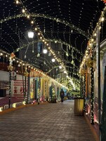 Una escena nocturna en la calle con luces decorativas y un camino adoquinado.