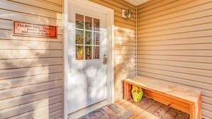 Una puerta de madera con un letrero que dice "The Bear Cove - Casa 5 Vivienda de Alquiler Bienvenidos a Alaska!"