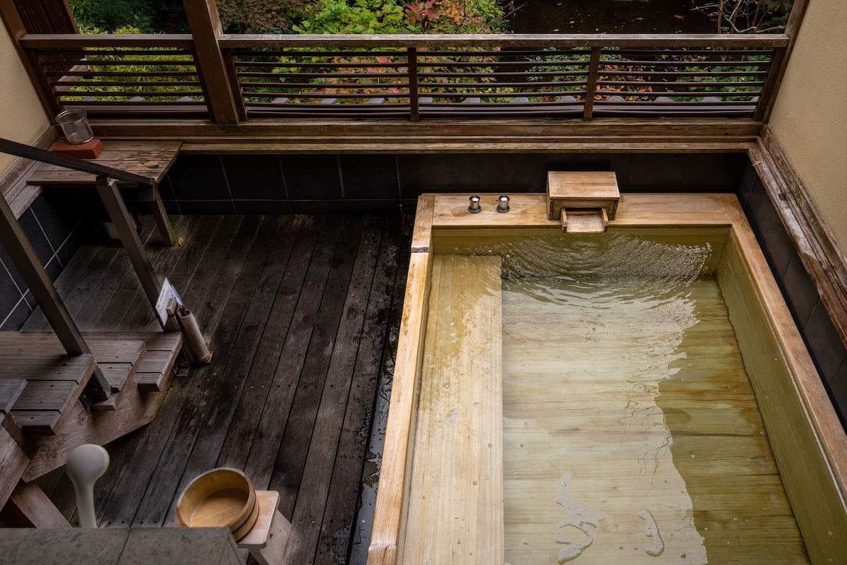 A wooden bath area with a wooden bench and a small wooden tub.