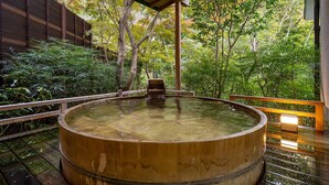 A wooden hot spring bath surrounded by lush greenery. - Tsurumaki Onsen Motoyu Jinya (Hadano)