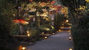 A pathway lined with lanterns and trees with autumn foliage. - Tsurumaki Onsen Motoyu Jinya (Hadano)