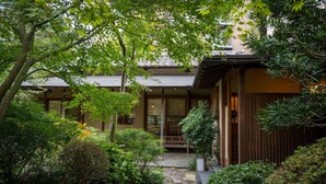 A traditional Japanese-style building with a wooden exterior, a tiled roof, and a stone pathway leading to the entrance. - Tsurumaki Onsen Motoyu Jinya (Hadano)