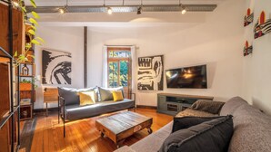 A modern living room with a grey sofa, wooden coffee table, and a TV mounted on the wall. - MOT Dorrego 2200 (Buenos Aires)