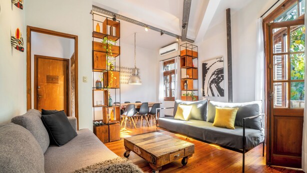 A cozy living room with a sofa, coffee table, and a wooden bookshelf. - MOT Dorrego 2200 (Buenos Aires)