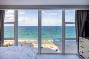 Habitación de hotel con un amplio ventanal con vistas a la playa.