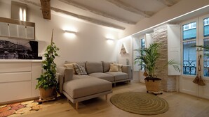 A modern living room with a sofa, potted plants, and a wooden floor. - History, comfort, and unique style, just 2 minutes from the beach. (Lekeitio)