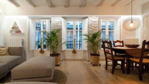 A cozy living room with a sofa, a dining table with chairs, and potted plants. - History, comfort, and unique style, just 2 minutes from the beach. (Lekeitio)