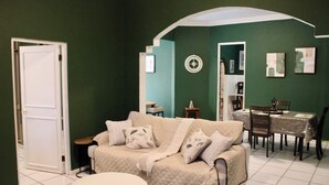 A living room with a sofa, a round table, and a dining area. - Vintage Charm n Historic Miramar (San Juan)