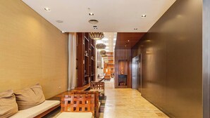 A modern hotel lobby with a long wooden bench, a sofa, and a fireplace. - Modern High End Studio Palermo T107 (Buenos Aires)