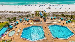 A beachside resort with multiple swimming pools, sun loungers, and umbrellas. - The Summit 1019-toes in the Sand (Panama City Beach)