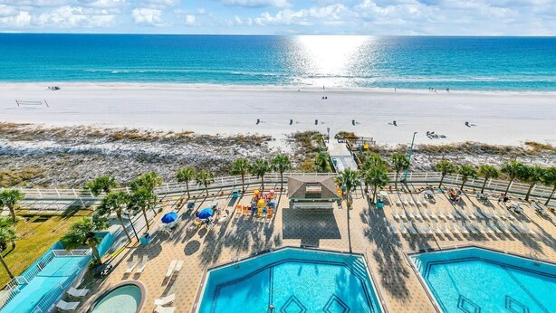 A beach resort with multiple swimming pools, sun loungers, and a view of the ocean. - The Summit 1019-toes in the Sand (Panama City Beach)