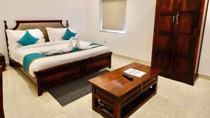 Une chambre d’hôtel avec un lit en bois, une table de chevet avec une télécommande, une armoire en bois et une fenêtre donnant sur un paysage agréable.