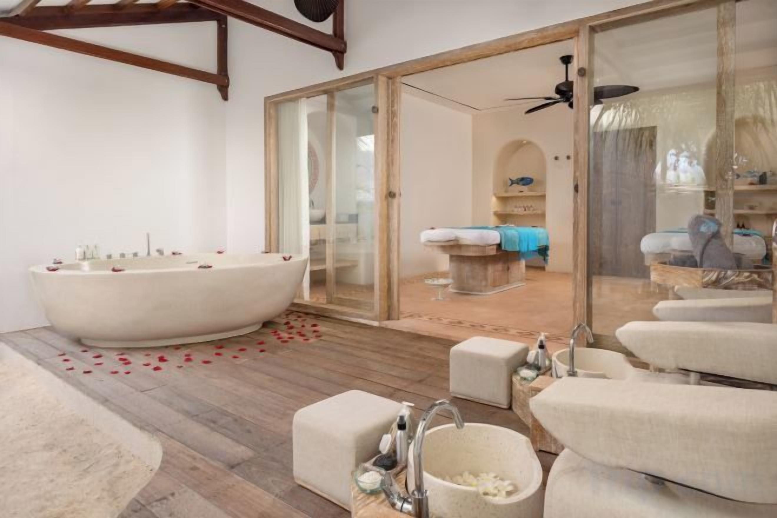 A spacious bathroom with a large bathtub, a separate sink area, and a shower.