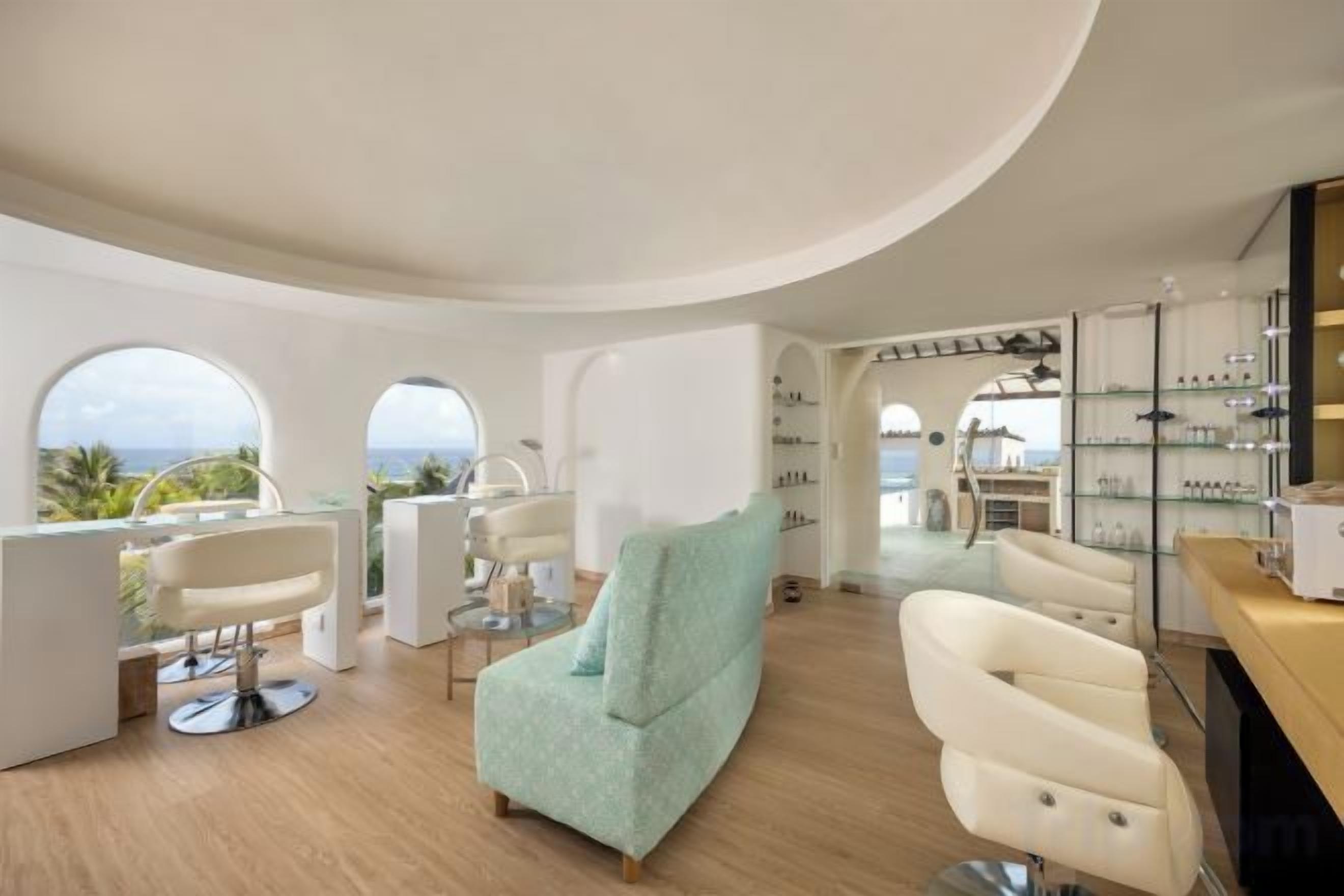 Um interior moderno com teto curvo, um sofá verde-água e um espaço bar com prateleiras.
