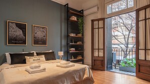 Une chambre avec un grand lit, une bibliothèque et une vue sur l’extérieur.