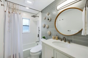 Une salle de bain moderne équipée d’une baignoire, de toilettes et d’un lavabo.
