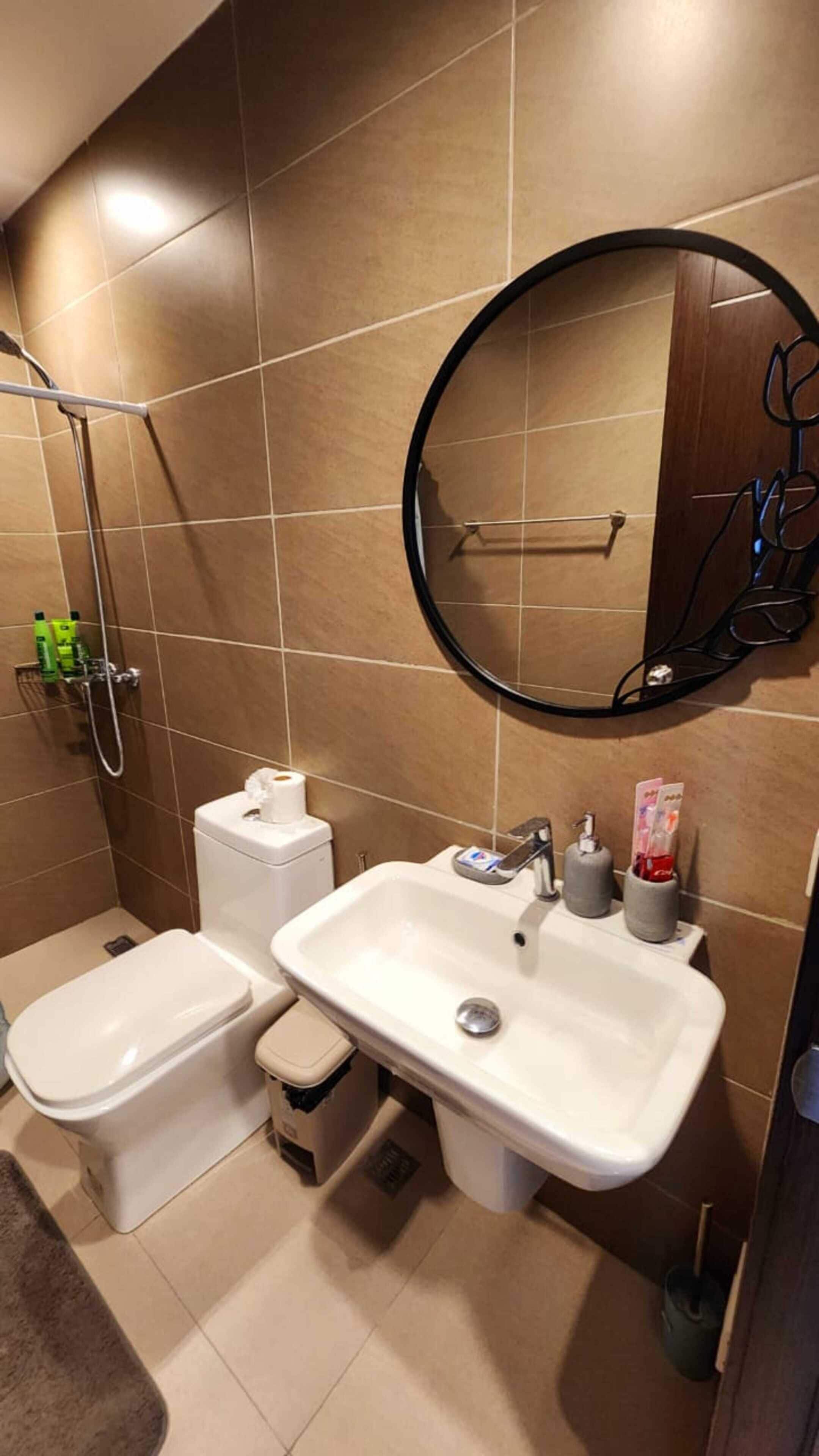 A modern bathroom with a toilet, sink, and shower.