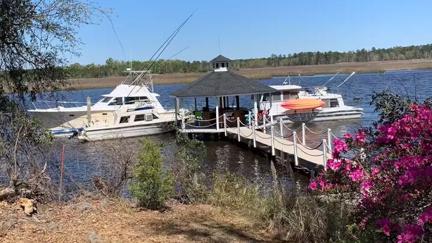 A dock with boats, a gazebo, and a forested shoreline. - Take a break in nature (Georgetown)