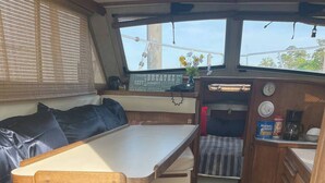 A compact kitchen area with a wooden table, a bench, and a small sink. - Take a break in nature (Georgetown)