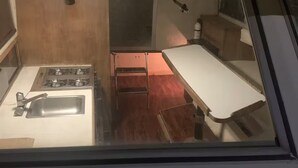 A compact kitchen with a gas stove, sink, and a small countertop. - Take a break in nature (Georgetown)