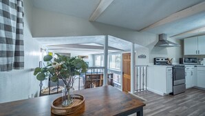 A modern kitchen with white cabinets, a stainless steel range hood, and a built-in oven. - Serenity Hideaway, Charming 2bd/1ba cabin with WiFi, AC, close to shops (Ruidoso)