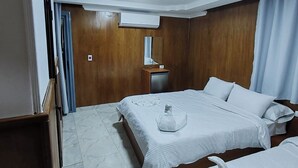 A hotel room with two beds, a wooden wardrobe, a small desk with a mirror, and a ceiling light. - Del Celio Hotel (Cairo)