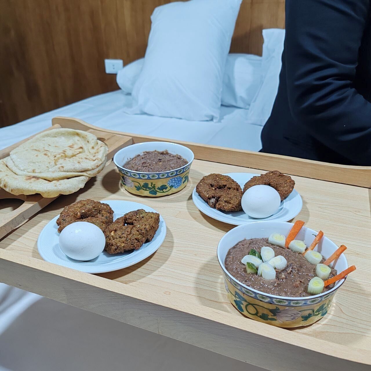 Un plateau de petit-déjeuner avec du pain plat, des biscuits et un bol de soupe garni de légumes.