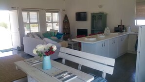 Ein kompakter Wohnbereich mit Sofa, Esstisch und Küchenzeile.