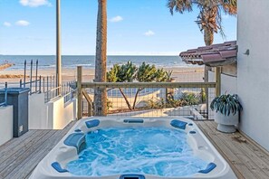 Un jacuzzi con vista a la playa y palmeras.