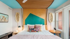 Ein Schlafzimmer mit einem Bett, einem Nachttisch, einem runden Tisch und einem Fenster.