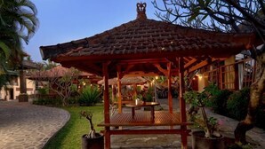 A gazebo with a tiled roof, surrounded by potted plants and a stone pathway. - Banyualit Spa 'n Resort Lovina (Bali)