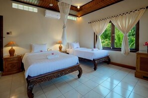 A hotel room with two beds, a wooden ceiling, and a large window with curtains. - Banyualit Spa 'n Resort Lovina (Bali)