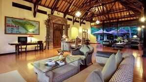 A spacious living area with a high ceiling, wooden beams, and comfortable seating. A map of Bali is displayed on the wall. - Banyualit Spa 'n Resort Lovina (Bali)