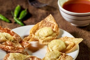 En tallerken stegte dumplings med dyppesauce.