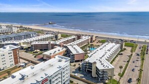 Ein Hotel an der Küste mit mehreren Gebäuden, einem Parkplatz und Blick auf den Strand.