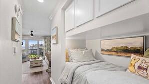 Ein Schlafzimmer mit einem Bett, einem Fenster und einem Bild an der Wand.