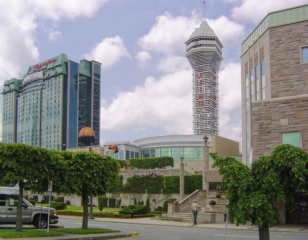 A modern hotel with a distinctive tower, a large glass building, and a stone structure.