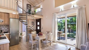 A spacious kitchen with a built-in refrigerator, wooden cabinets, and a staircase leading to an upper level. - Rigilis - Two Bedroom Villa, Sleeps 4 (Nydri)
