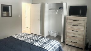 Makuuhuoneessa on sänky, vaatekaappi, televisio ja pyykkikori.