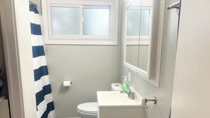 Kylpyhuone, jossa on wc, pesuallas ja ikkuna.