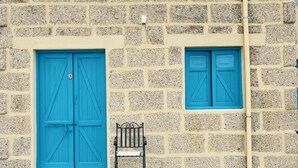A building with two blue doors and a bench in front. - Las Cuevas - 3 bed finca in a serene setting (CN)