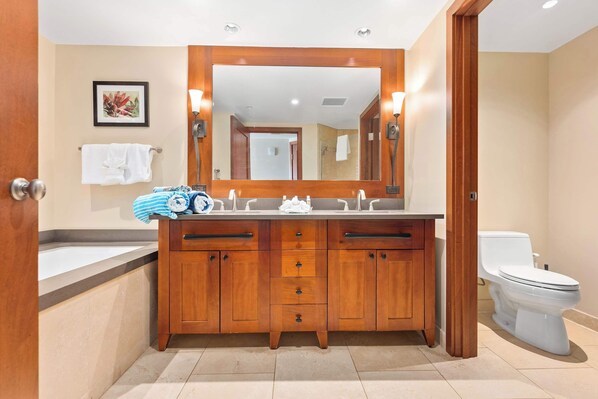 A modern bathroom with a wooden vanity, a large mirror, and a white toilet.