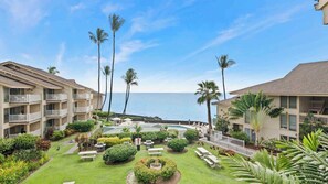 Ein Resort mit mehrstöckigen Gebäuden, einem zentralen Poolbereich und Blick auf den Ozean.