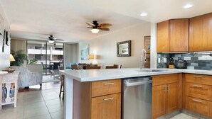 Una cocina moderna con armarios de madera, lavavajillas y una isla grande.
