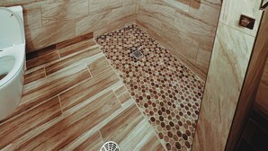 A modern bathroom with a shower area, tiled walls, and a wooden floor. - Walk to food & drinks, near lakes (Mossyrock)